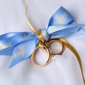 Two wedding rings tied together with custom ribbons.