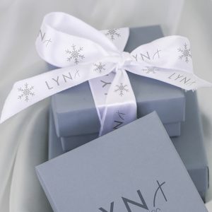 Using one of the key benefits of ribbon, a gift box is wrapped with ribbons that have text and graphics.