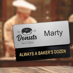 A badge ribbon with promotional text is attached to a bakery shop's name tag.