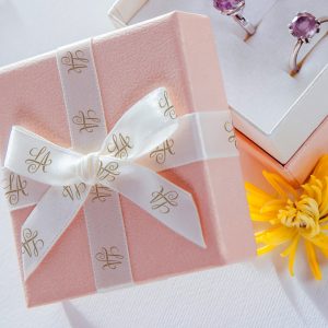 A product box lid with a ribbon and a bow attached.